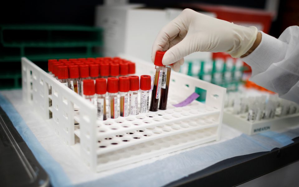 A health worker takes test tubes with plasma and blood samples after a separation process in a centrifuge during a coronavirus disease (COVID-19) vaccination study at the Research Centers of America, in Hollywood, Florida, U.S., September 24, 2020. REUTERS/Marco Bello
